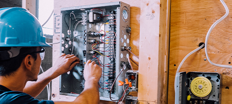 Aviron Technical Institute of Montreal Student Electrician working under a panel